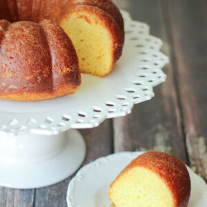 This bunt style coconut rum cake is made from yellow cake mix and styled on a white cake pedestal.