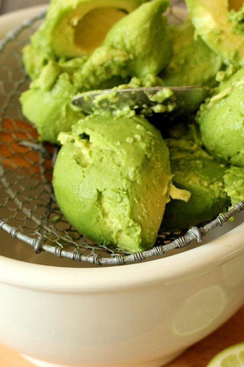 Avocados sit in a frying spider ready to be pressed through for the perfect texture of guacamole. 
