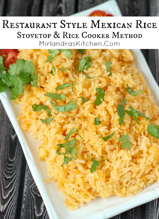 Savory golden Mexican rice fills a white platter. It is garnished with cilantro and sliced tomatoes.