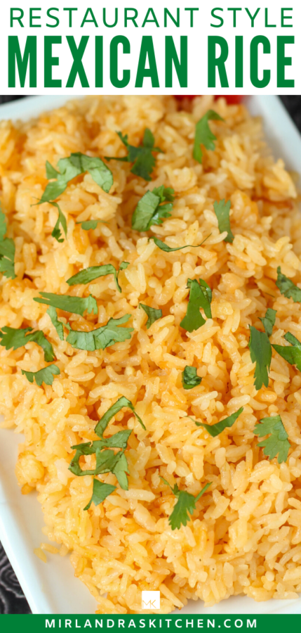 A platter of savory restaurant style Mexican rice that is garnished with cilantro and a few sliced tomatoes.