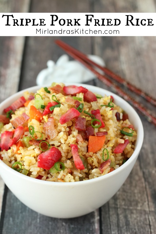 A white bowl of fried rice sits on a farmhouse table.  You can see bacon, bbq pork, rice, and green onion.
