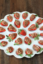 This deviled egg plate is full of chocolate cheesecake deviled strawberries! Each strawberry is sliced in half and has chocolate cheesecake filling piped into it. Delicious!