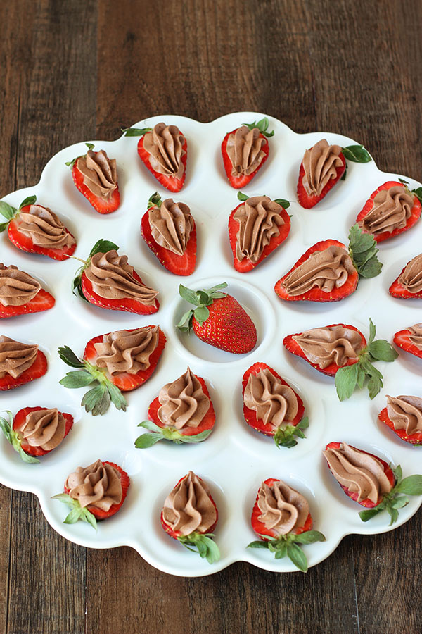 This deviled egg plate is full of chocolate cheesecake deviled strawberries! Each strawberry is sliced in half and has chocolate cheesecake filling piped into it. Delicious!