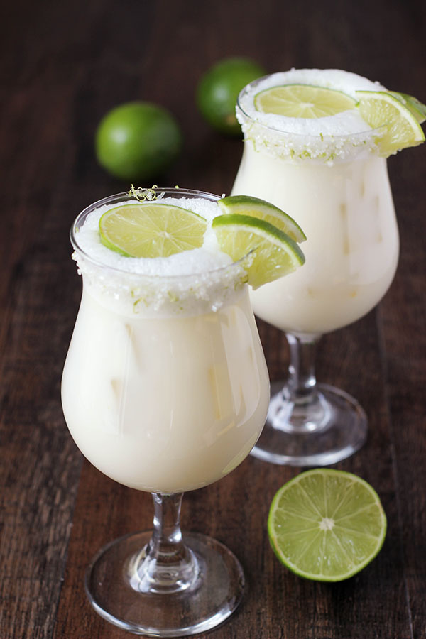 Tall refreshing glasses of Brazilian Lemonade garnished with limes.