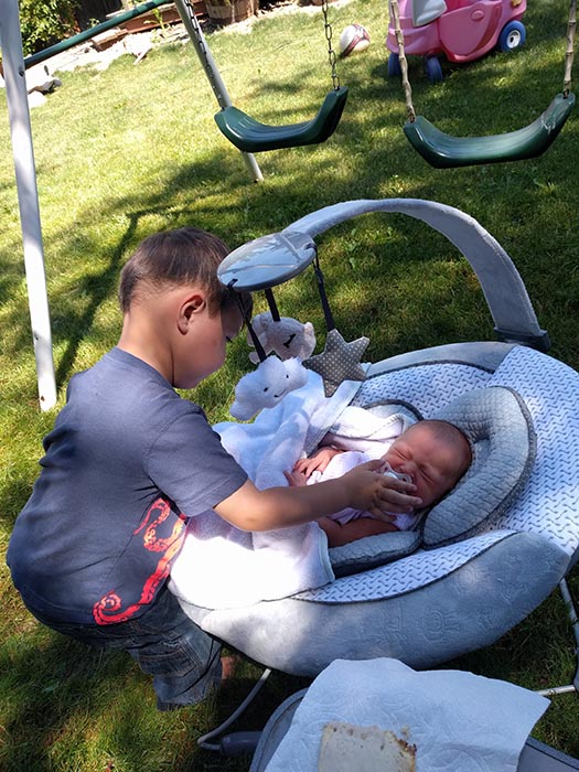 Jack's first week as a big brother.  He is putting a binky into Ella's mouth as she sleeps in her bouncer.