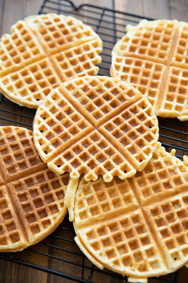 Crispy, fluffy buttermilk waffles rest on a baking rack to prevent them getting soggy. Never stack hot waffles!