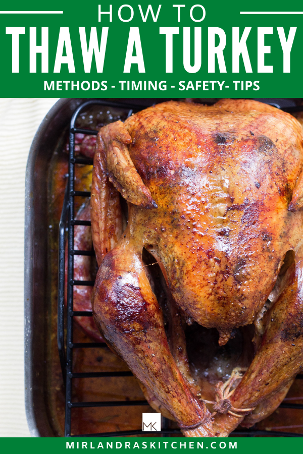 A large roasted turkey rests in a roasting rack. There is writing on the image for promotional purposes. 