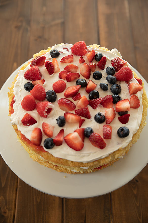 What a layer of berry Chantilly cake looks like when assembling it.  The jam, cream, and berries on a layer of yellow cake.