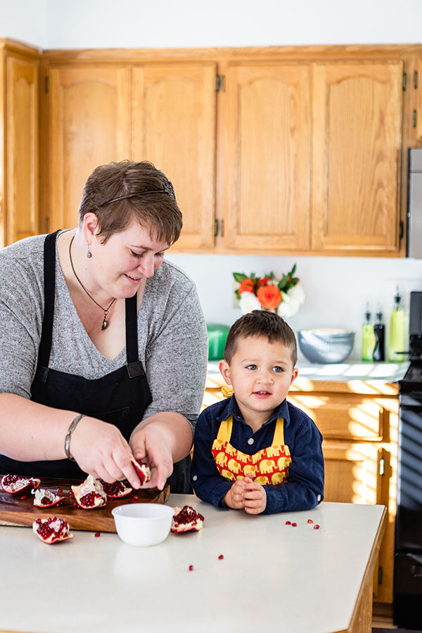 Mirlandra and Jack open up a pomegranate in the kitchen with some essentials like a set of mixing bowls.