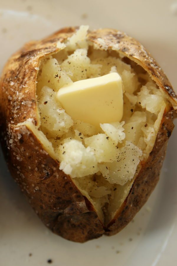 This is a lovely, fluffy baked potato cut open to see the delicious inside of the potato.  It has butter on top and a potato chip crispy skin.