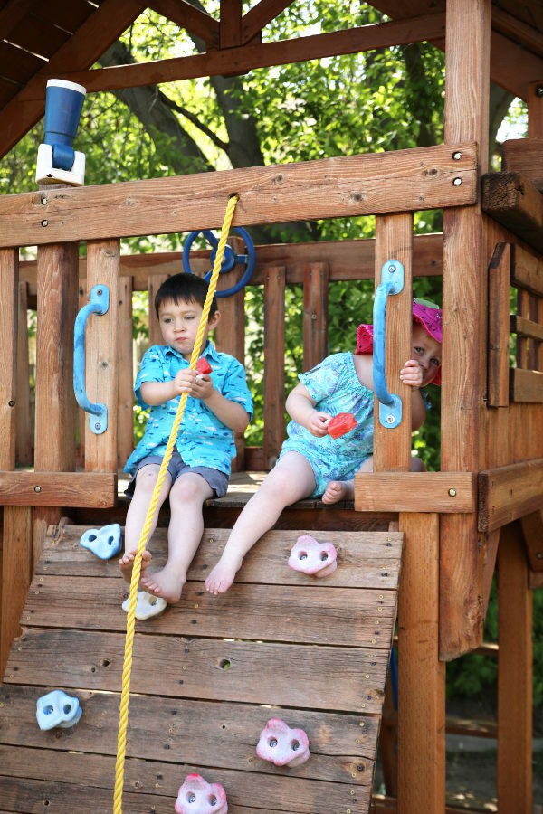 Ella peaking out of the fort with a watermelon tree while she sits next to Jack.