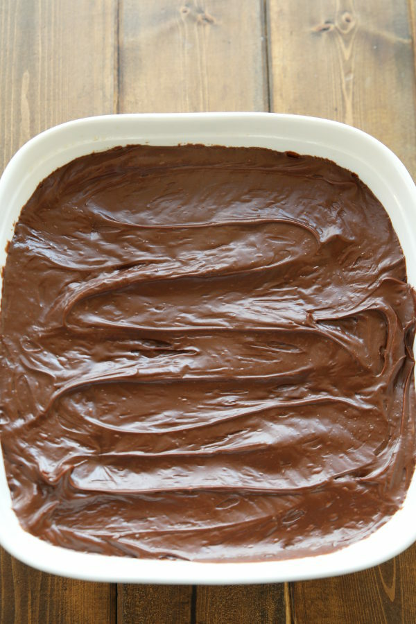 This wacky cake is a chocolate cake, frosted with chocolate frosting in a white square pan.