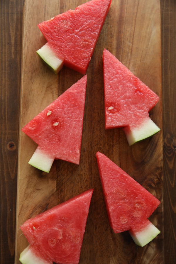 A cutting board of watermelon triangles cut into watermelon trees.