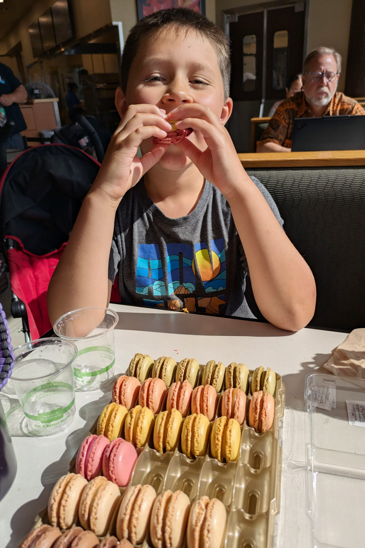 An 9 year old boy eating macaroons in the airport after going through TSA. 