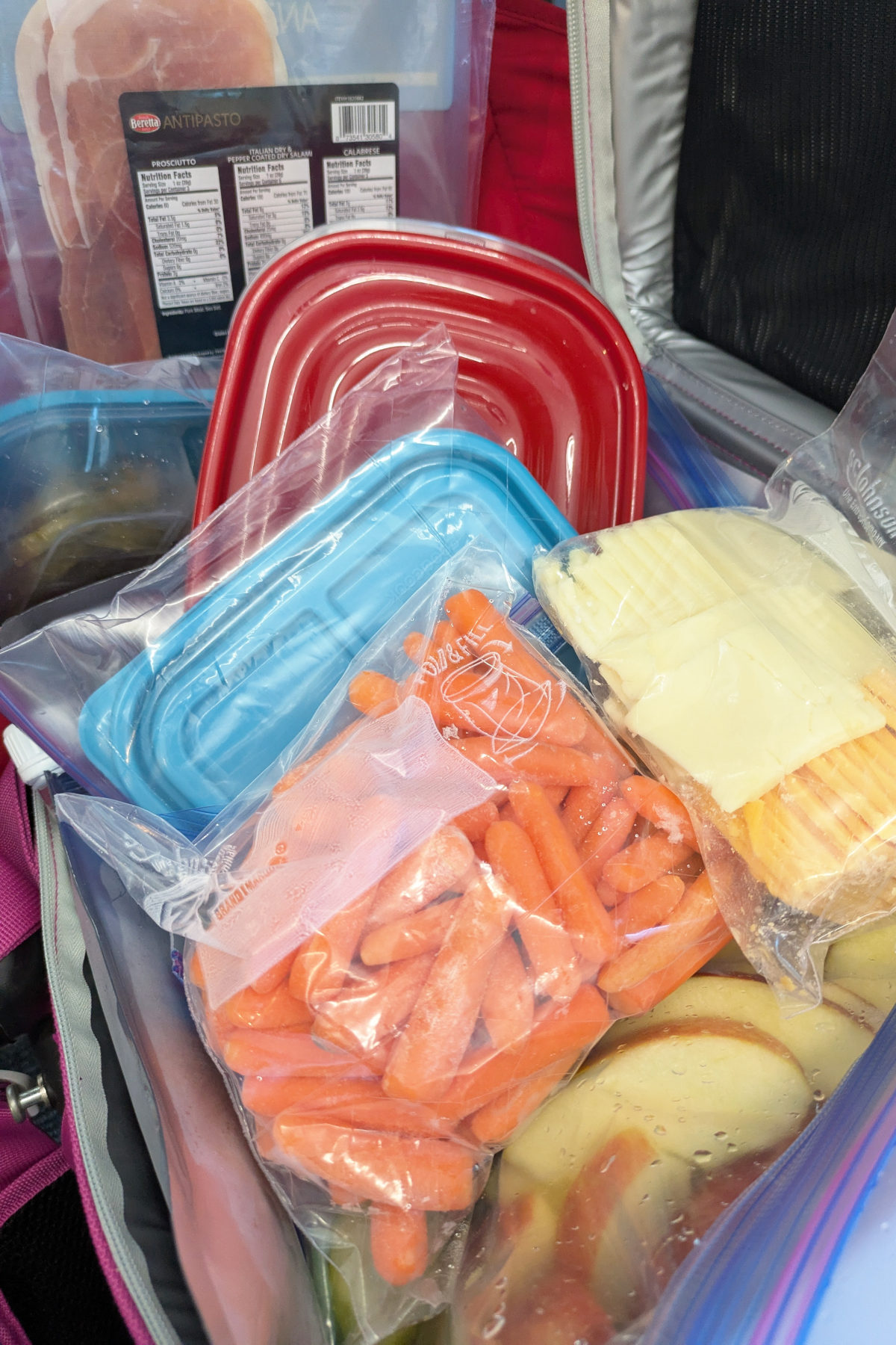 a soft pack carry on cooler overflowing with veggies, cheese and meat after it went through TSA.