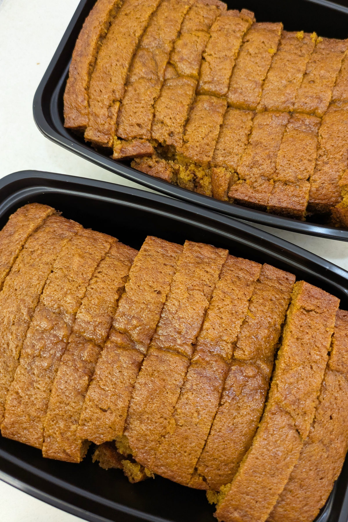Sliced pumpkin bread in gladware packed for the airport. 