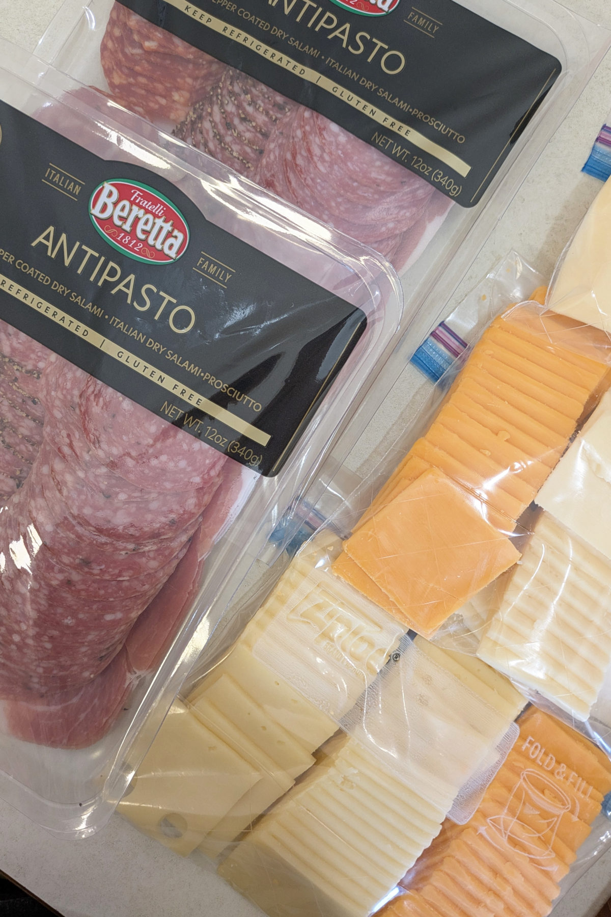 salami and sliced cheese on a table after going through TSA in a cooler
