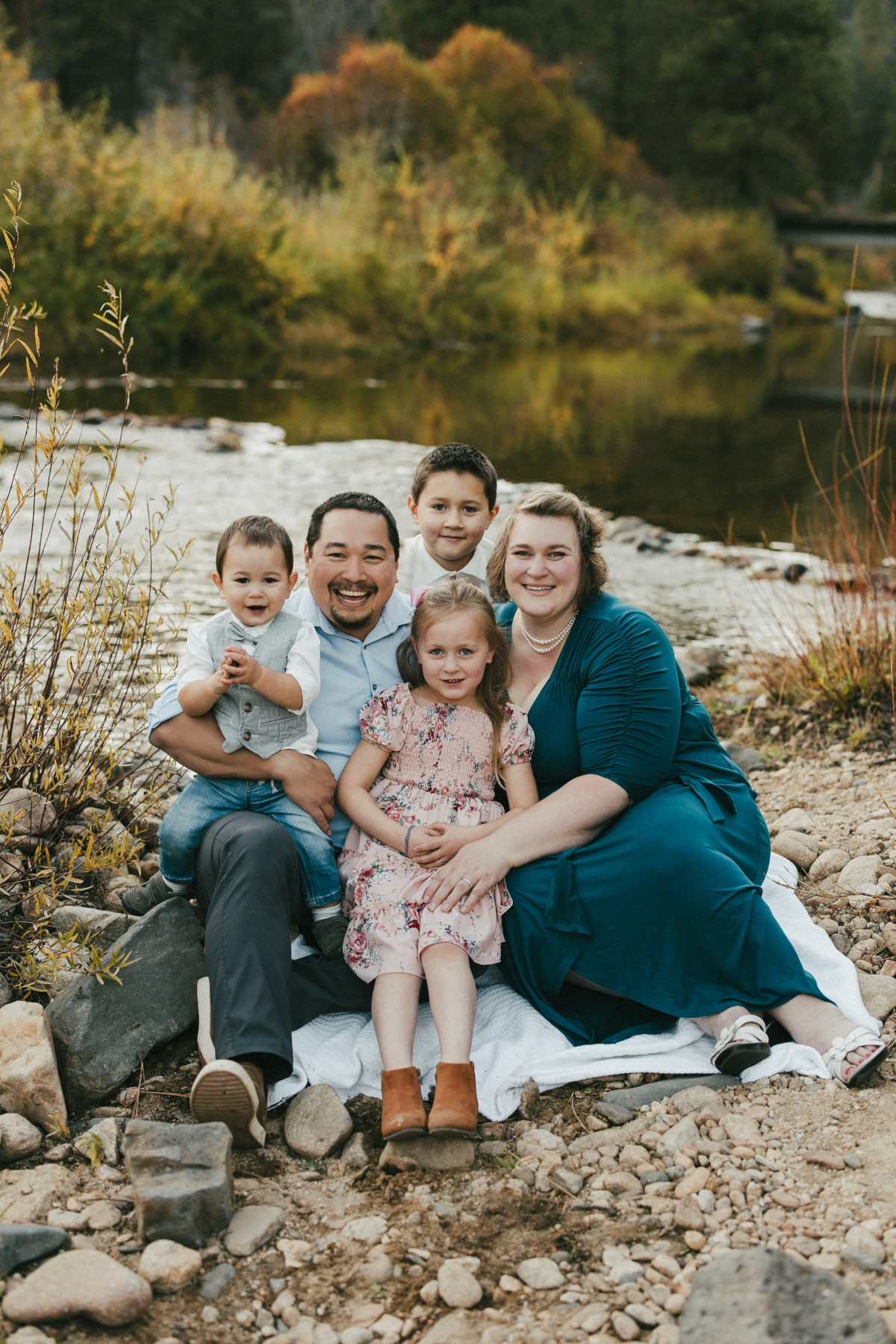 Mirlandra Neuneker and family on a blanket by a creek.
