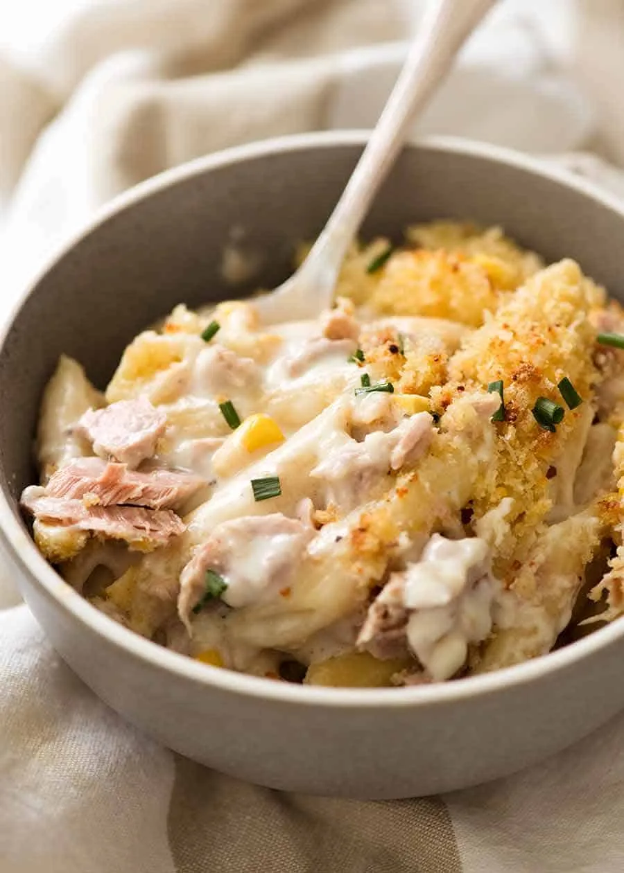 A brown bowl with creamy tuna and noodles with a crunchy topping. 