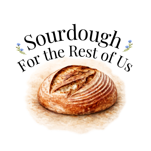 An artisan sourdough loaf with the words "Sourdough for the rest of us" and decorated with blue cornflowers