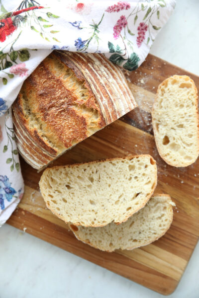 A sliced loaf of homemade bread showing the internal crumb, a perfect example of sourdough for beginners with a golden crunchy crust and soft interior.