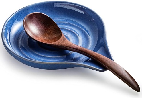 Blue ceramic spoon holder with a dark color wooden spoon in it.