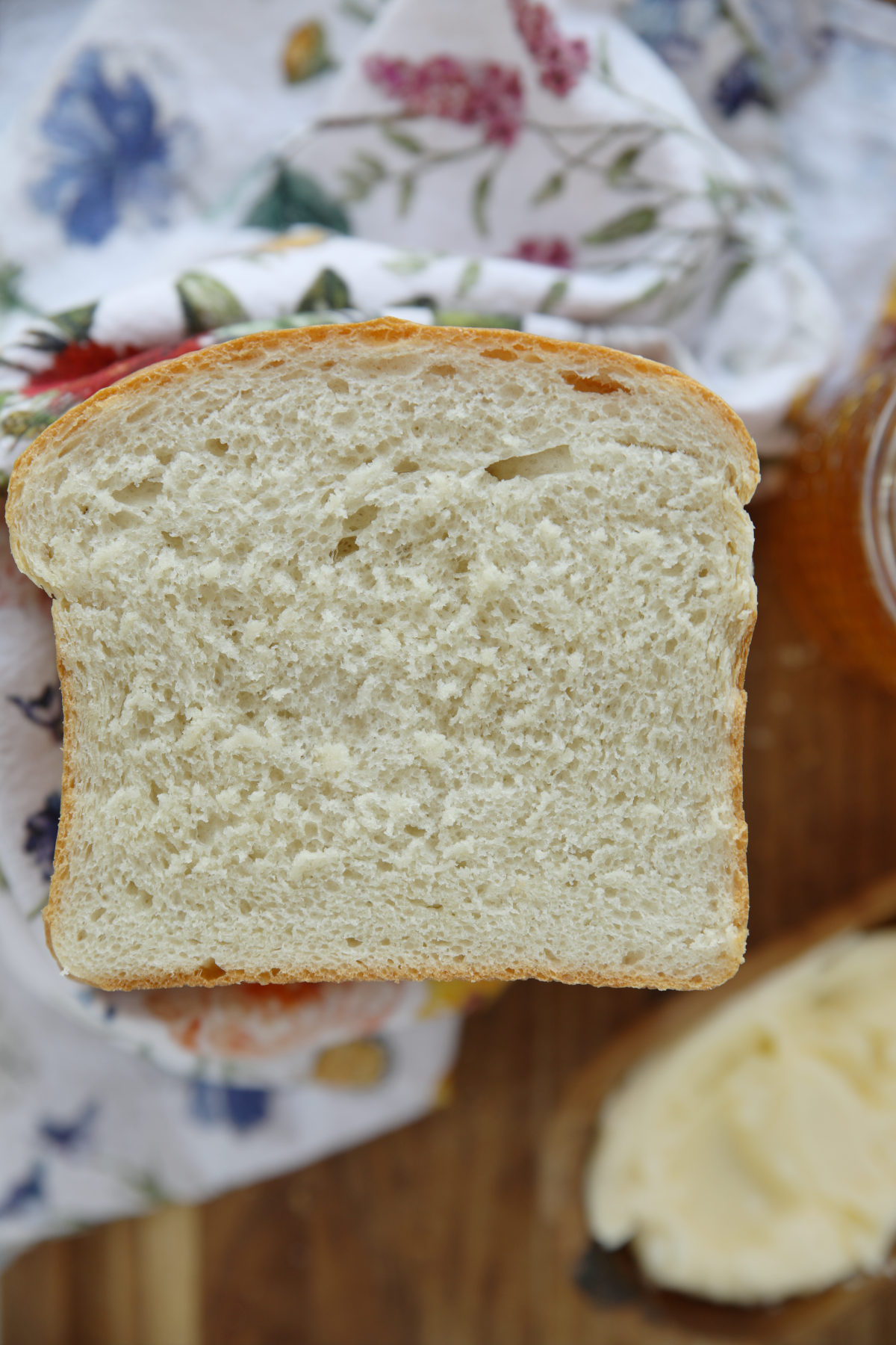A close up slice of sourdough discard sandwich bread showing the soft tender crumb and golden crust