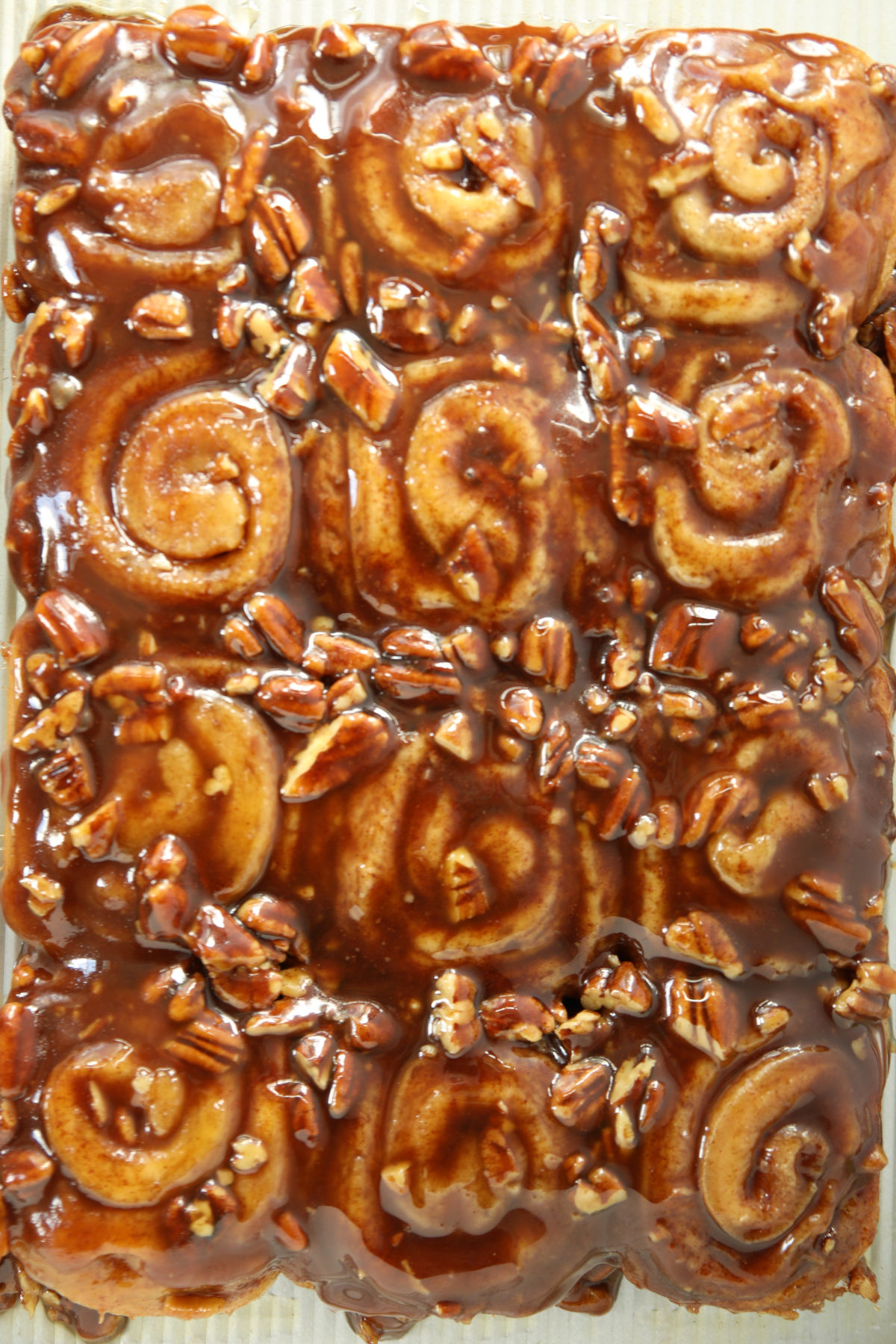 Sourdough discard sticky buns with pecans just after flipping, showing the full pan of caramel pecan syrup coating every bun